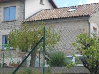 a fence in front of a house with a building at Gite du plô in La Cresse