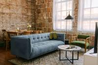 ein Wohnzimmer mit einem blauen Sofa und einer Ziegelwand in der Unterkunft Sonder by Marriott Bonvoy The Schaeffer Apartments French Quarter in New Orleans