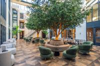 a courtyard with chairs and a tree in a building at Eilandhotel Texel - Nieuw geopend hotel in De Cocksdorp