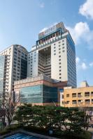 Un edificio alto con una piscina enfrente. en Toyoko Inn Daejeon Government Complex, en Daejeon