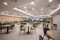 AquaMed Hotel Harkány في هاركاني: غرفة طعام مع طاولات وكراسي