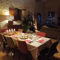 een eettafel met een kerstboom op de achtergrond bij Clos Baroanni - Chambre Oléa in Terraube