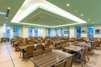 uma sala de jantar com mesas, cadeiras e janelas em Spa Resort Hawaiians Monolith Tower em Iwaki