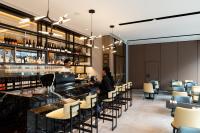 two people sitting at a bar in a restaurant at Hotel Grand Chancellor Auckland in Auckland