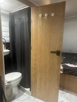 ein Badezimmer mit einem WC und einer Holztür in der Unterkunft קרוואן על הים in Eilat