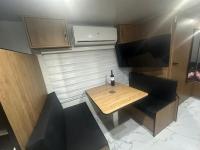 ein kleiner Tisch mit einer Flasche Wein darauf in einem Wohnwagen in der Unterkunft קרוואן על הים in Eilat