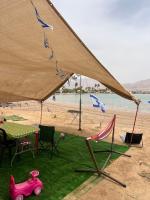 ein rosa Spielzeugauto, das unter einem Zelt am Strand steht in der Unterkunft קרוואן על הים in Eilat