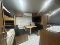 ein kleines Zimmer mit einem Tisch und einem Waschbecken. in der Unterkunft קרוואן על הים in Eilat