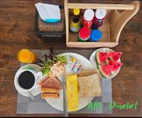 a table with two plates of food and a cup of coffee at Chiang Mai Waroros Boutique Hotel in Chiang Mai