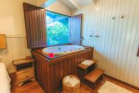 a large bathroom with a tub in a window at Pousada Vila Tamarindo Eco Lodge in Florianópolis
