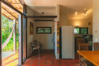 a kitchen with a refrigerator and a table in a room at Pousada Vila Tamarindo Eco Lodge in Florianópolis