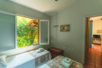 a room with a window and a bed and a table at Pousada Vila Tamarindo Eco Lodge in Florianópolis