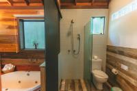 a bathroom with a shower and a toilet and a tub at Pousada Vila Tamarindo Eco Lodge in Florianópolis