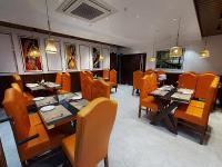 a dining room with tables and chairs in a restaurant at Hotel Kavaka in Sambalpur