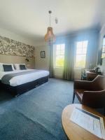Un dormitorio con una cama, un sofá y una mesa. en Cedars Inn by Greene King Inns, en Barnstaple