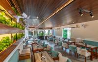 een restaurant met houten plafonds en tafels en stoelen bij B Town Resort Kakkanad Kochi in Cochin