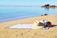 a person laying on a beach next to the water at Holiday Home Lukica in Privlaka