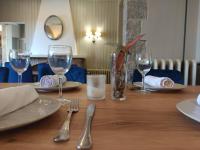a wooden table with glasses and utensils on it at Hotel restaurant Xalet la Coromina in Viladrau