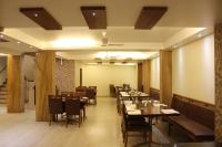 ein Restaurant mit Tischen und Stühlen in einem Raum in der Unterkunft Sunny International in Mahabaleshwar