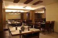 ein Esszimmer mit Holztischen und Stühlen in der Unterkunft Sunny International in Mahabaleshwar