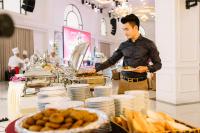 Un uomo che tiene un piatto di cibo a buffet di Duc Huy Grand Hotel and Spa a Lao Cai