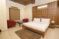 Un dormitorio con una cama, una silla y una mesa. en Hotel Razia Inn, en Hisār