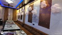 Hotel Atithi Food Village في Etāwah: صف من الطاولات في مطعم مع بالونات على الحائط