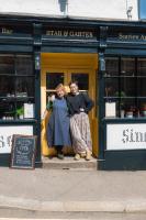 twee vrouwen die voor een gele deur staan bij Star & Garter in Falmouth