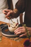 una persona que sirve comida con una cuchara en un tazón en un plato en Hotel Puerta del Sur, en Valdivia