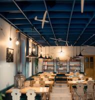 ミエンジブロジェ・ジビエツキエにあるŻarliwe Klimaty - gościniecの青い天井の部屋に並んだテーブルと椅子