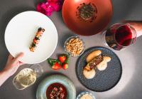 クラレンダイクにあるBoutique Hotel Bougainvilleaのテーブルの上に盛り付けられた料理とワインを楽しめます。