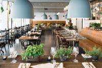 a restaurant with wooden tables and chairs and lights at Scandic Sundsvall City in Sundsvall