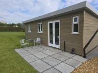 una casa pequeña con 2 sillas y una mesa en Dunroaming Cabin, en Pendine