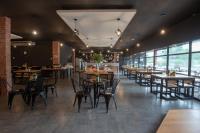 un ristorante con tavoli e sedie in legno e finestre di Hotel Seri Malaysia Ipoh a Ipoh