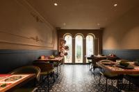 Un restaurante con mesas y sillas y una ventana. en SIXI CANGSHAN MOUNTAINS GOLDEN SUNRISE MIRROR OF THE SKY SOUND SLEEP HOTEL DALI ANCIENT CITy, en Dali