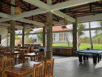 een restaurant met een pooltafel en houten tafels en stoelen bij Charm Hon Rom Villas Resort in Ấp Long Sơn