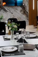 un tavolo con piatti e bicchieri e un vaso con fiori di Luxury Hotel By Gjyshi a Qerrexhias