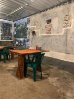 セナルにあるIza home stayの部屋にある大きな木製のテーブルと緑の椅子