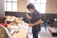a woman holding a plate of food at a buffet at Celestial Manor in Lucknow