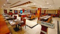 a dining room with tables and chairs and a restaurant at MM Legacy - A Bergamont Hotel, Kanchipuram in Kanchipuram