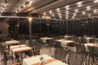a dining room with tables and chairs and lights at Brow City Kaş in Kas