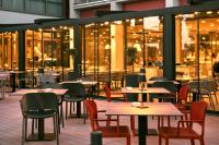 ein leeres Restaurant mit Tischen, Stühlen und Fenstern in der Unterkunft Remisens Hotel LUCIJA in Portorož
