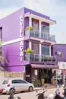 un edificio púrpura con coches aparcados delante de él en Hotel Açaí, en Itaituba