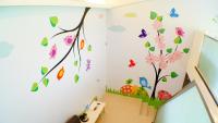 a childs room with a wall mural of a tree and butterflies at Lan Yang Resort Four Seasons in Dongshan