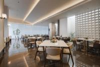 um restaurante com mesas e cadeiras em uma sala em Atour Hotel Chongqing West Railway Station Xinqiao Hospital em Chongqing