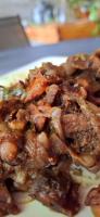 un plato de comida con carne y cebolla en Kot Nou - Kwizine Mama Manze Lakaz, en Mahébourg