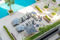 eine Draufsicht auf einen Pool mit Stühlen und Sonnenschirmen in der Unterkunft Chalet Homes - LUX New Studio With 2 Double Beds in Downtown Dubai in Dubai