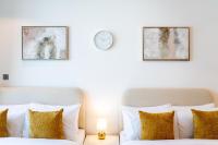 ein Schlafzimmer mit 2 Betten und einer Uhr an der Wand in der Unterkunft Chalet Homes - LUX New Studio With 2 Double Beds in Downtown Dubai in Dubai