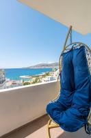 Una silla en un balcón con vista al mar. en SoleLuna Aparthotel, en Sarandë