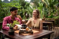 een man en een vrouw aan een tafel met een bord eten bij Nham Village Resort in Ninh Binh